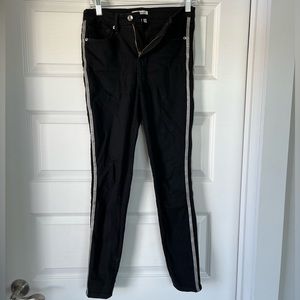 Good American black jeans with silver stripes down the side.